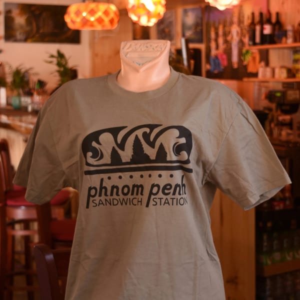 A mannequin wears a gray Phnom Penh Sandwich Station t-shirt with a black logo.